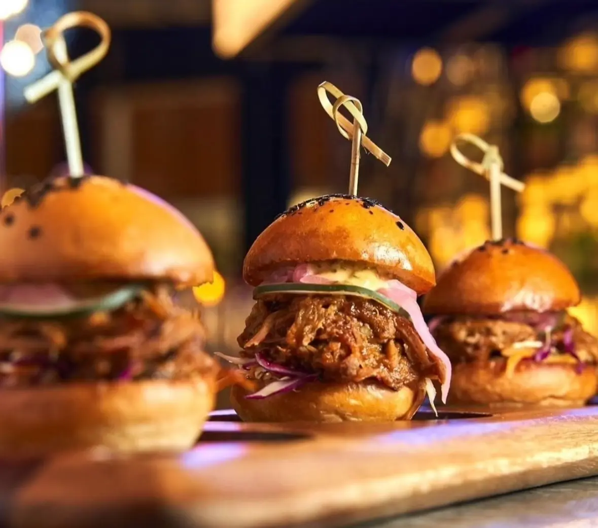 Oaxacan fried chicken sliders on a wooden board