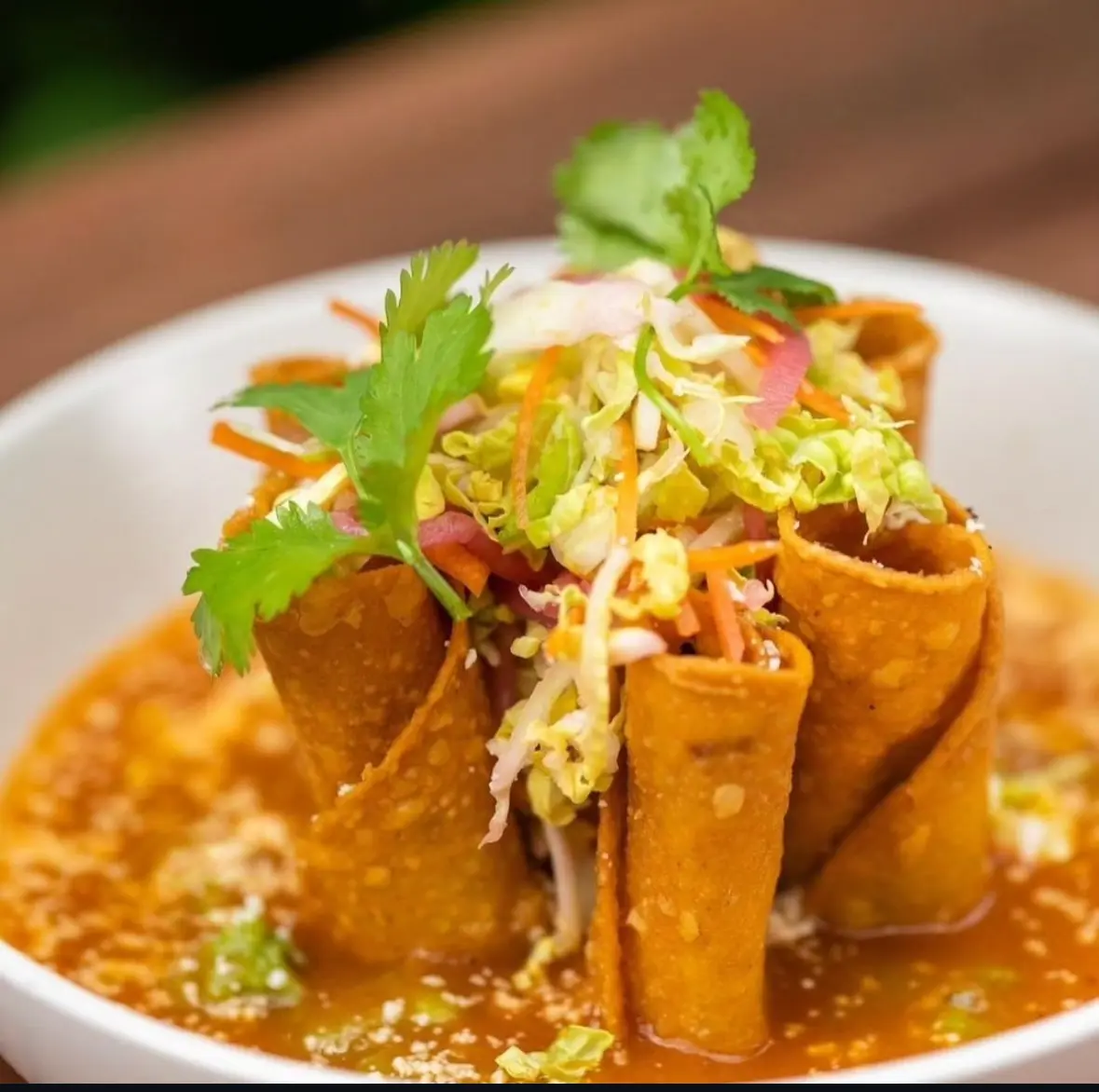 Potato and rajas flautas standing in salsa
