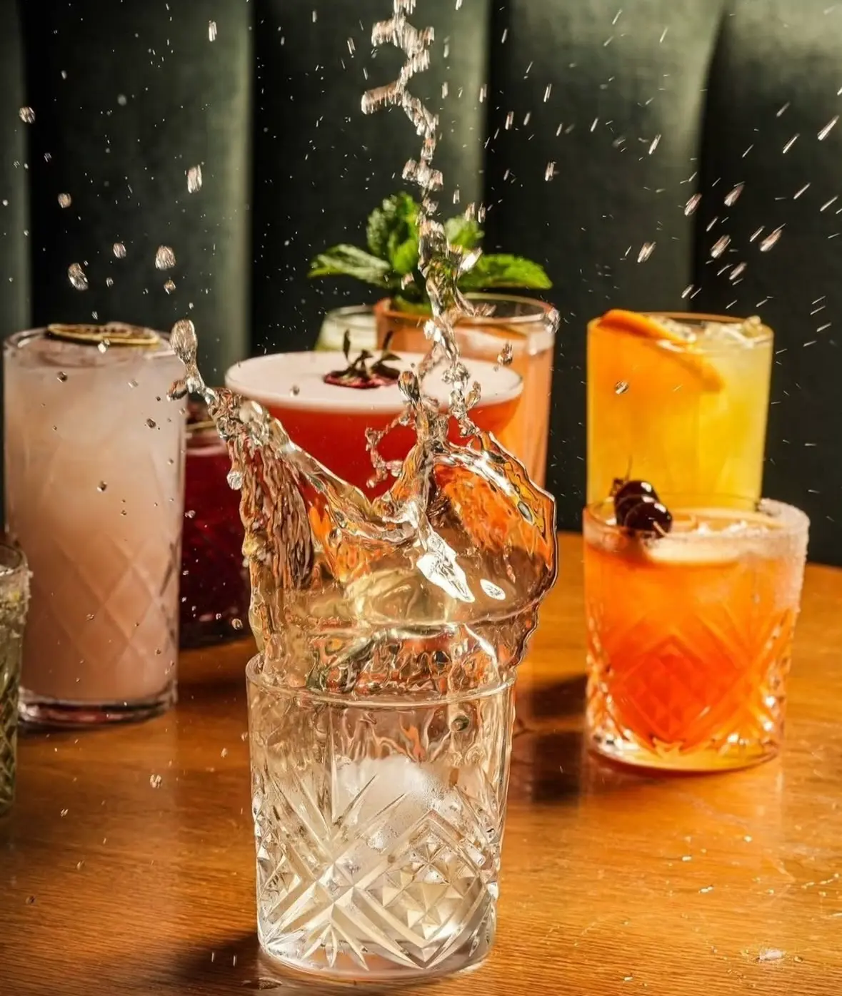 Cocktails mid-pour with a splash of ice
